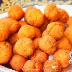 Bonbons piment réunionnais dorés et épicés servis dans une barquette métallique.