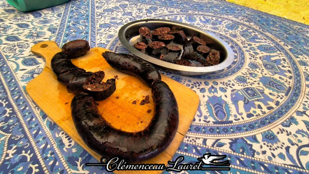 Vue d'ensemble d'un pique-nique créole avec du boudin noir sur une planche et une nappe aux motifs bleus à La Réunion.