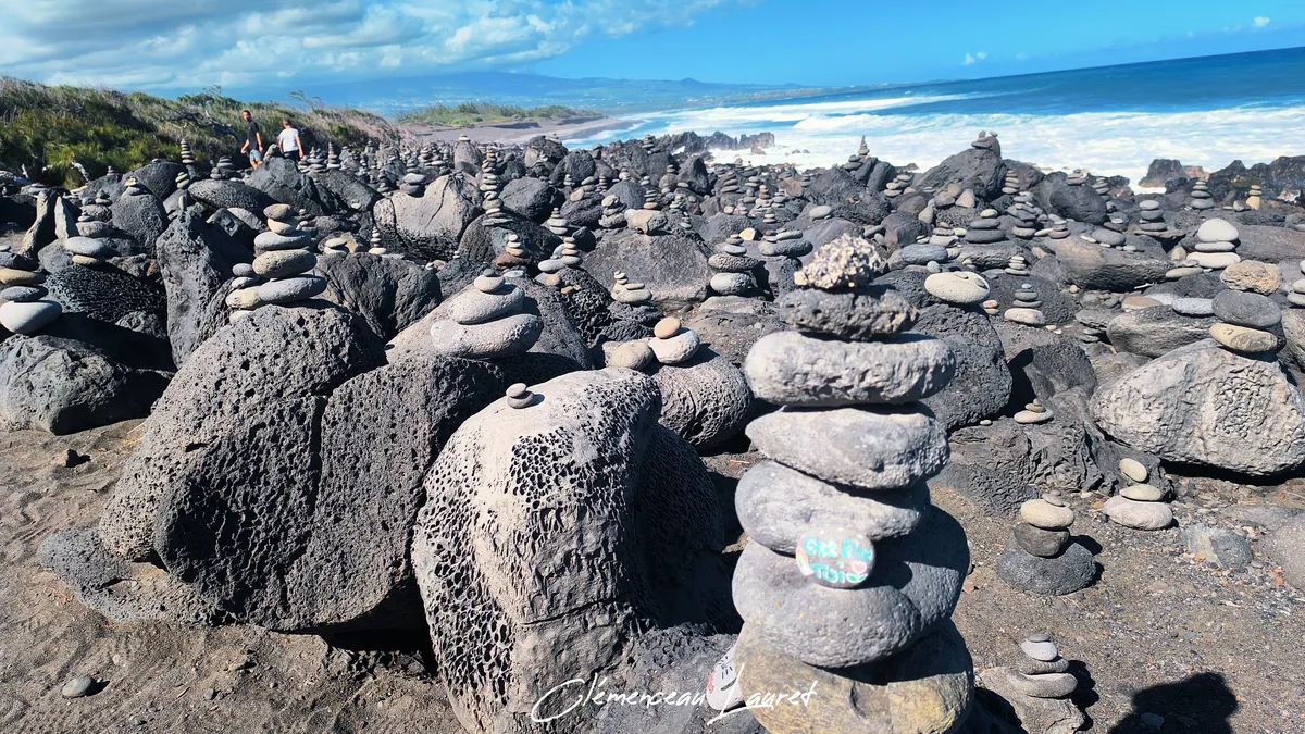 Champ de cairns de pierres sombres au bord de mer à L'Étang-Salé
