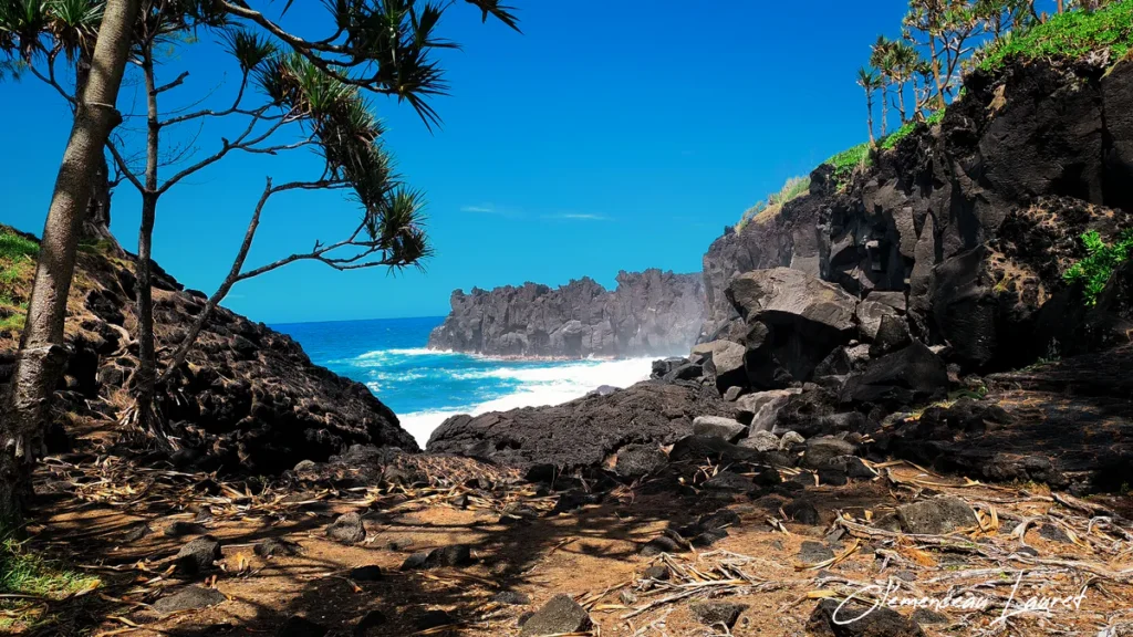 Ouverture rocheuse basaltique donnant sur l'océan bleu et les vagues déferlantes du Cap Méchant.
