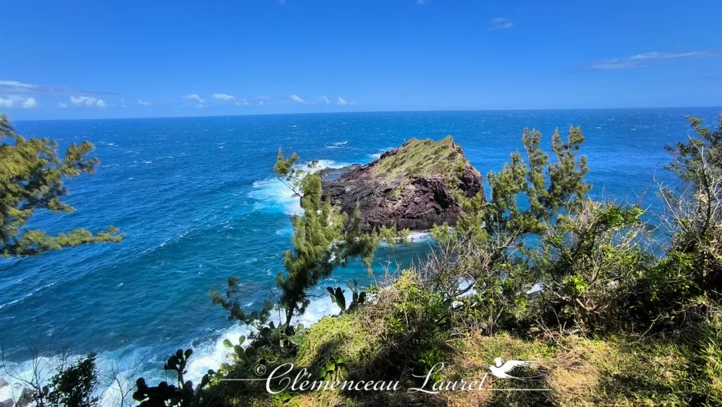 Vue panoramique sur l'îlot rocheux du Cap de Petite Île entouré par l'océan Indien bleu à La Réunion.