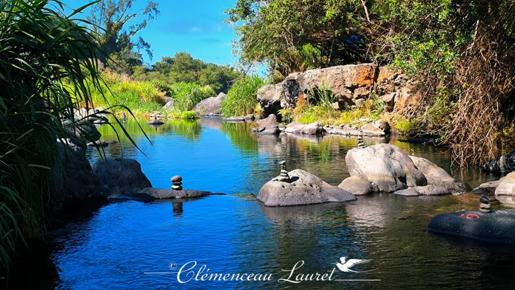 Cairns de galets posés sur les rochers le long du bassin bleu de la Rivière Langevin