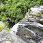 Plan rapproché du courant d'eau vive se déversant sur les rochers en basalte au sommet de la cascade Jacqueline à Saint-Joseph.