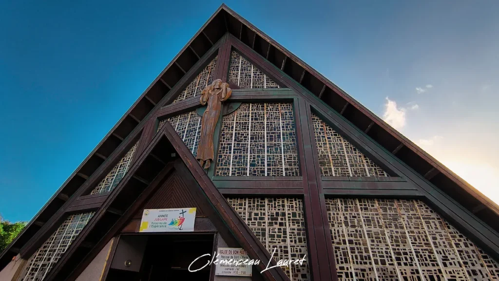 Gros plan sur le sommet de la façade de l'église du Bon Pasteur avec le grand Christ en croix en relief, Saint-Pierre.