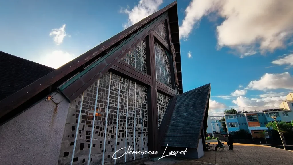 Côté droit de la façade de l'église du Bon Pasteur à Saint-Pierre montrant les murs ajourés laissant passer la lumière.