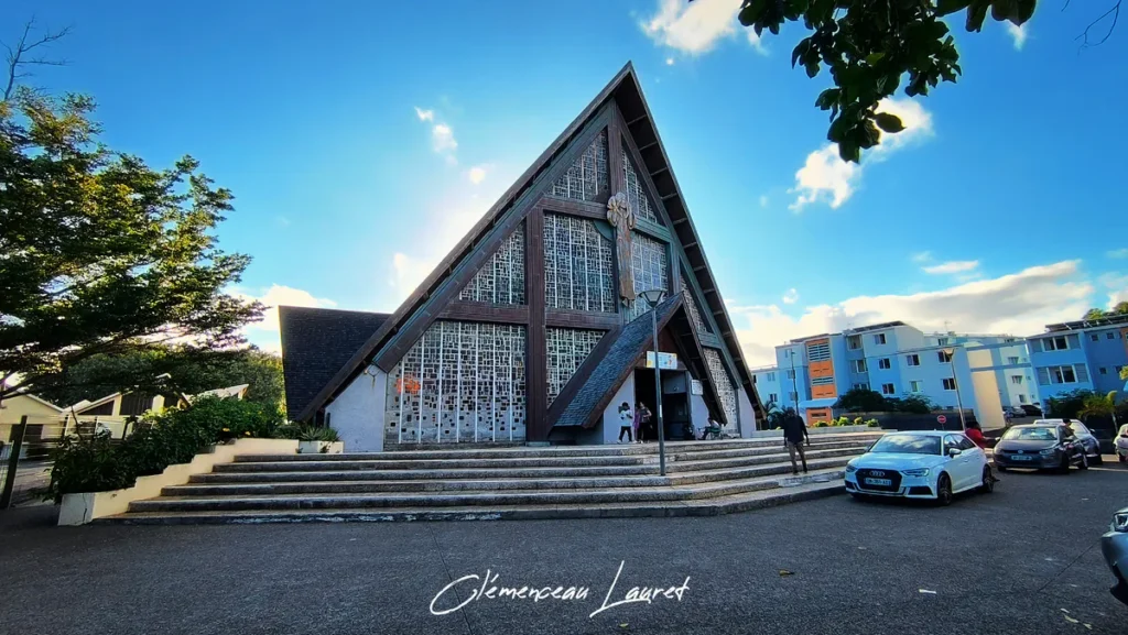 Vue d'ensemble de l'église du Bon Pasteur et de son parvis avec quelques visiteurs, à la Ravine Blanche, Saint-Pierre.