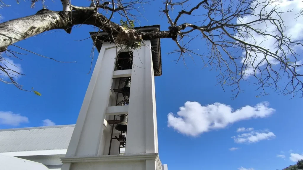 Clocher blanc de l'église Saint-Athanase de Vincendo sous un ciel bleu