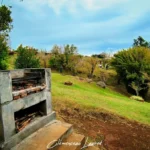 Barbecue en béton maçonné sur la pelouse verdoyante de l'aire de pique-nique du Piton Fougère à Sainte-Marie