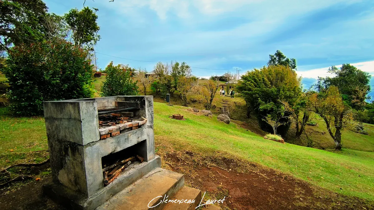 Barbecue en béton maçonné sur la pelouse verdoyante de l'aire de pique-nique du Piton Fougère à Sainte-Marie