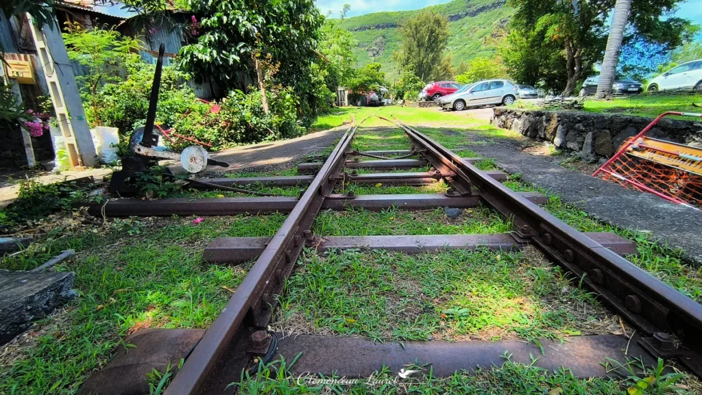Vue en contre-plongée des rails de chemin de fer en acier et du levier d'aiguillage manuel à La Grande Chaloupe.