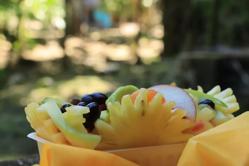 Plan rapproché sur une barquette de fruits de saison découpés avec piment cabri et jamblons à Saint-Paul, La Réunion.