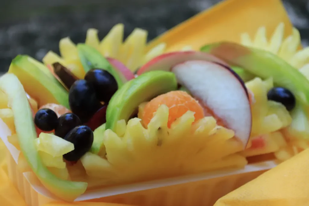 Vue en plongée d'une composition colorée de fruits tropicaux tranchés et pimentés sur un étal à Saint-Denis, La Réunion.