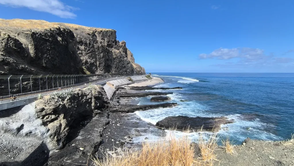 Littoral sauvage du Cap La Houssaye à Saint-Paul montrant la juxtaposition des falaises de basalte, des bandes de sable et des vagues froissées de l'océan Indien. Photo : Clémenceau Lauret (CC BY-SA 4.0)