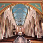 Vue intérieure en contre-plongée de la voûte bleue étoilée et des arcs ogivaux de la nef de l'église Notre-Dame de la Délivrance, à Saint-Denis, La Réunion — Photo : Clémenceau Lauret (CC BY-SA 4.0).