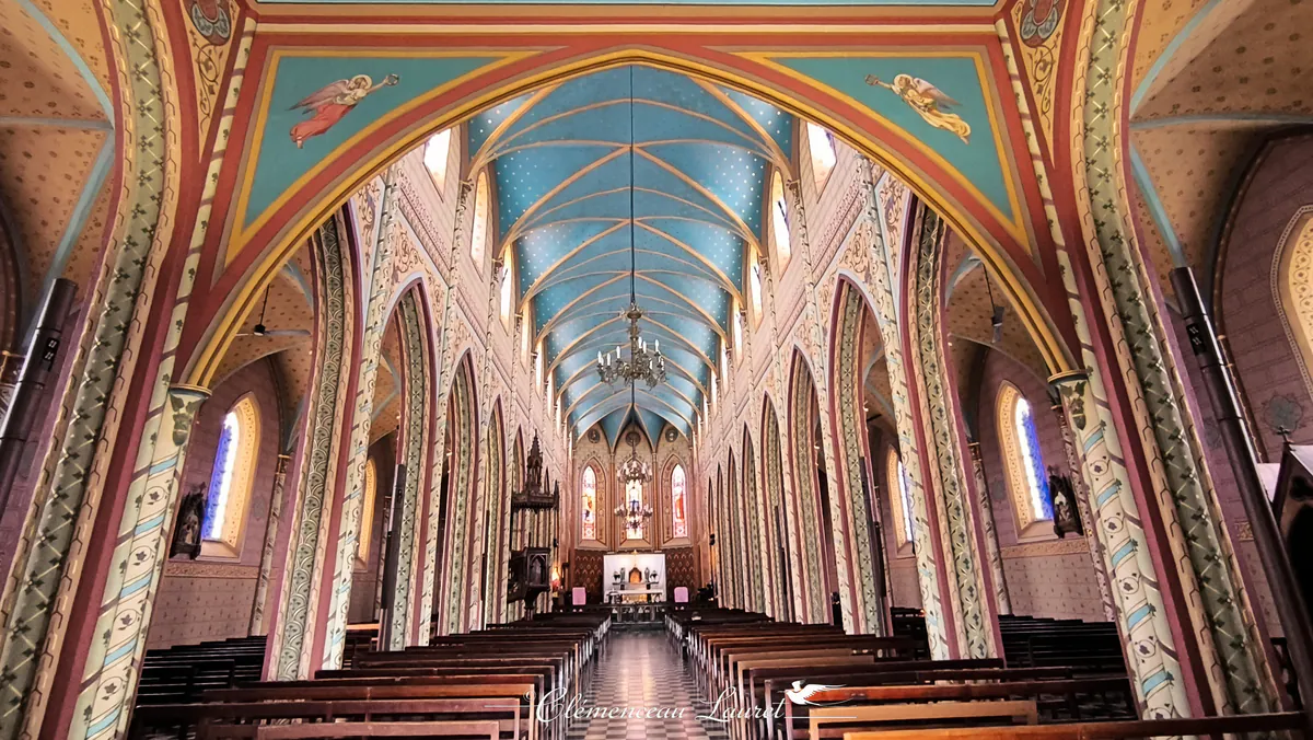 Vue intérieure en contre-plongée de la voûte bleue étoilée et des arcs ogivaux de la nef de l'église Notre-Dame de la Délivrance, à Saint-Denis, La Réunion — Photo : Clémenceau Lauret (CC BY-SA 4.0).