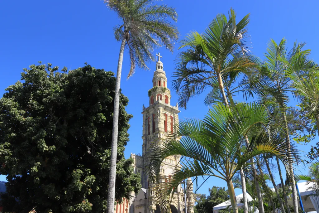 Plan large montrant les palmiers tropicaux s'élevant devant l'église baroque de Saint-Benoît.