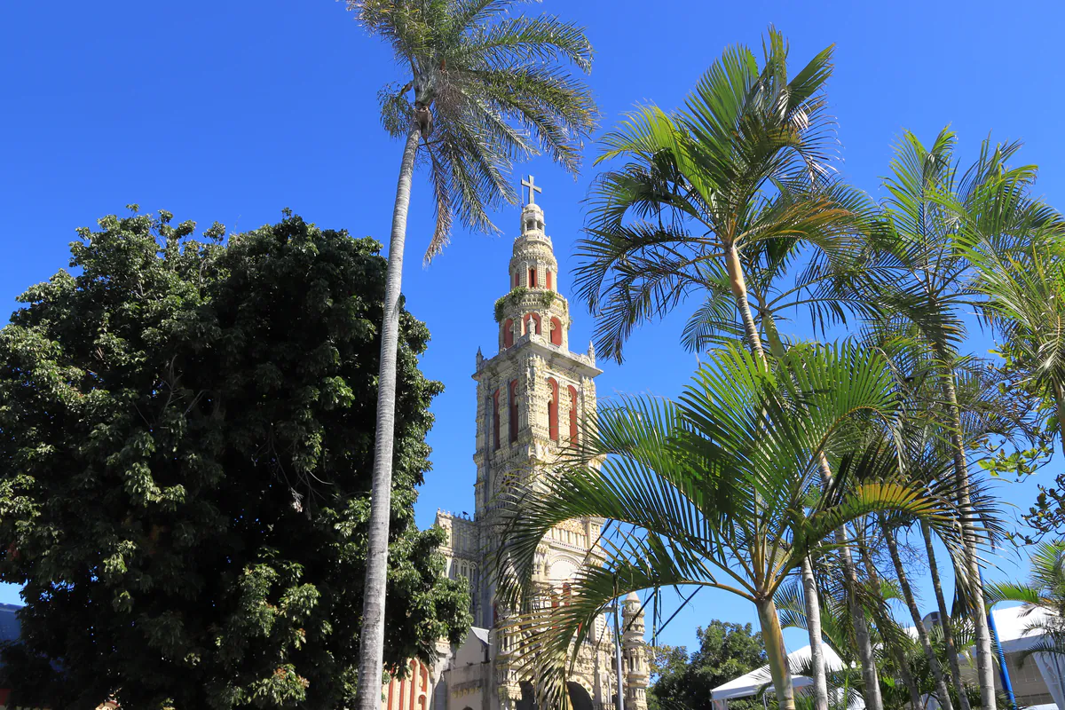 Plan large montrant les palmiers tropicaux s'élevant devant l'église baroque de Saint-Benoît.