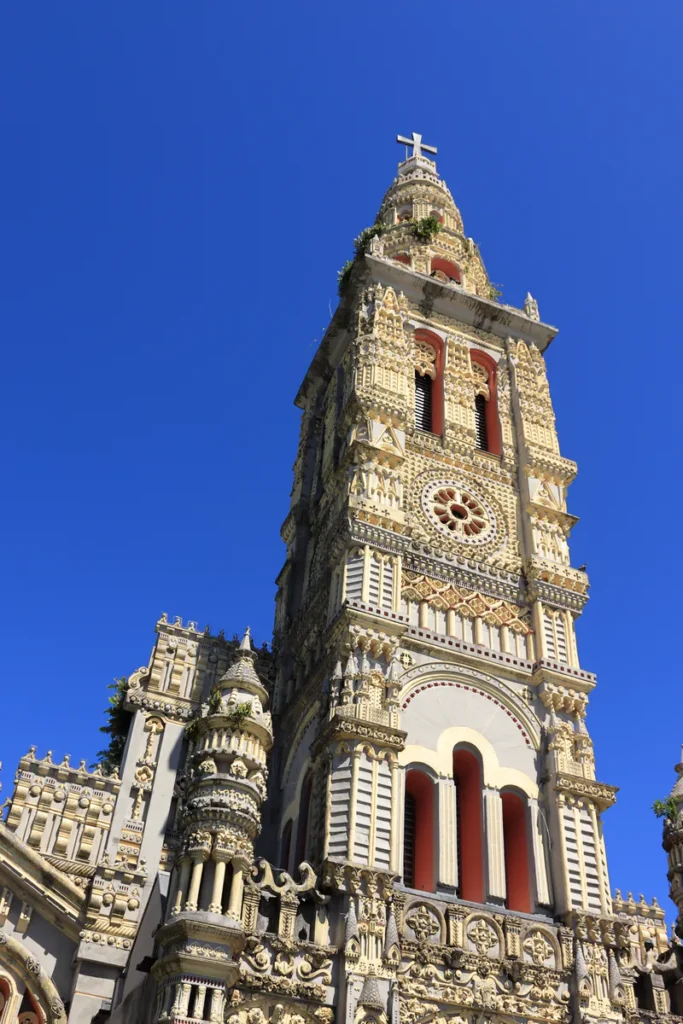 Gros plan sur les détails architecturaux et sculptés du clocher de Sainte-Anne à Saint-Benoît.