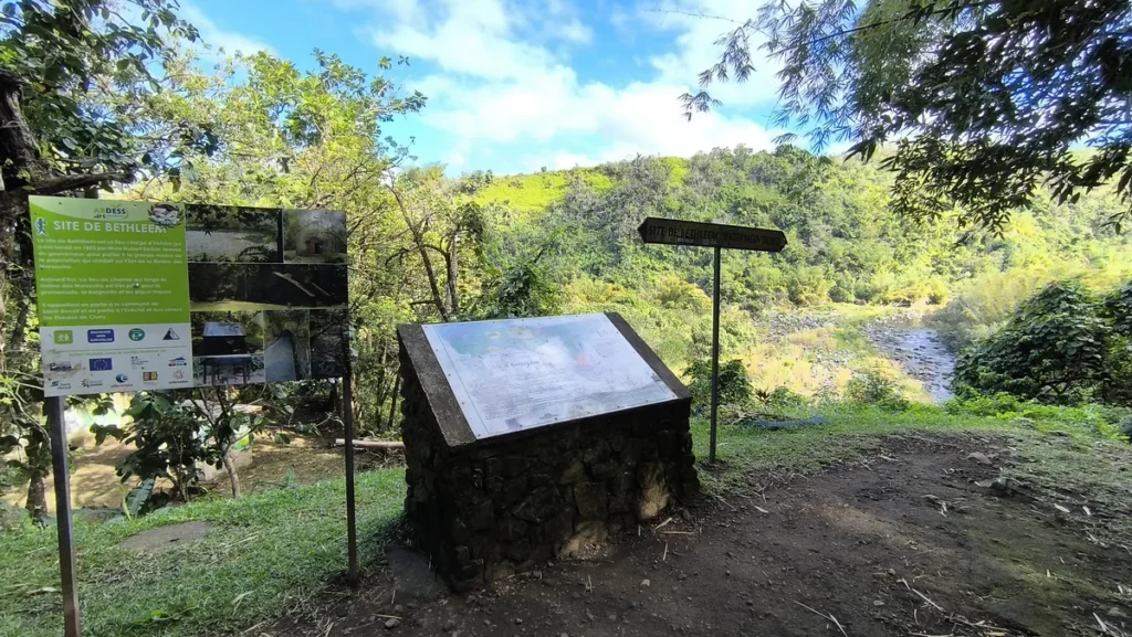 Panneaux d'information touristique et pupitre explicatif en pierre sur le site de l'Îlet Bethléem à Saint-Benoît