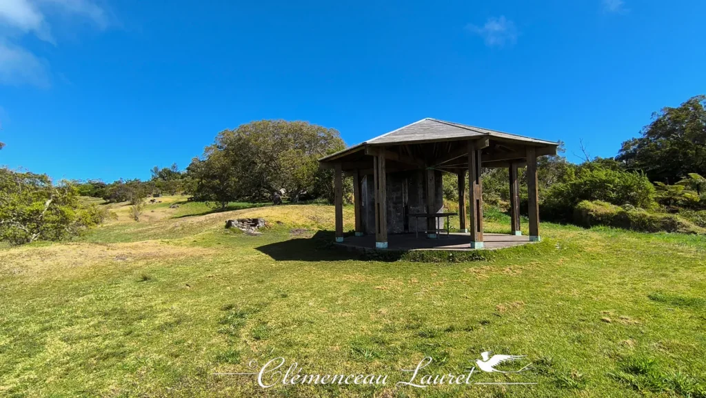 Kiosque en bois aménagé pour le pique-nique et le repos des randonneurs au cœur d'une clairière verdoyante sur le plateau du Dimitile à l'Entre-Deux, Île de La Réunion — Photo : Clémenceau Lauret (CC BY-SA 4.0).