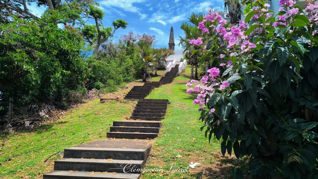 Escalier entouré de fleurs roses montant au mausolée de La Redoute à Saint-Denis