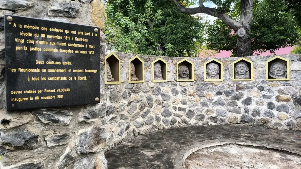 Gros plan sur la plaque noire commémorative gravée rappelant le souvenir des condamnés à mort de la révolte de novembre 1811, réalisée par l'artiste Richard Vildeman et inaugurée le 8 novembre 2011 à Saint-Leu. Photo : Clémenceau Lauret (CC BY-SA 4.0).