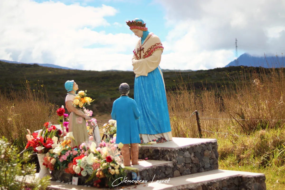 Vue d'ensemble de l'oratoire de Notre-Dame des Fougères à la Plaine des Cafres, représentant la Vierge de La Salette en robe bleue et blanche avec les bergers au pied d'un socle couvert de fleurs.