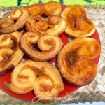 Vue aérienne d'une assiette remplie de palmiers feuilletés dorés posée sur un dessous de plat en vacoa tressé à Saint-Joseph, La Réunion. Prise de vue et photographie réalisées par Clémenceau Lauret.