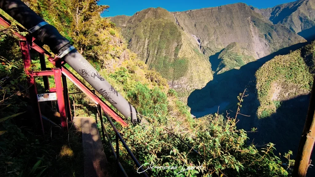 Tuyau d'eau en acier longeant la passerelle métallique au-dessus du gouffre de la ravine à Grand Bassin.