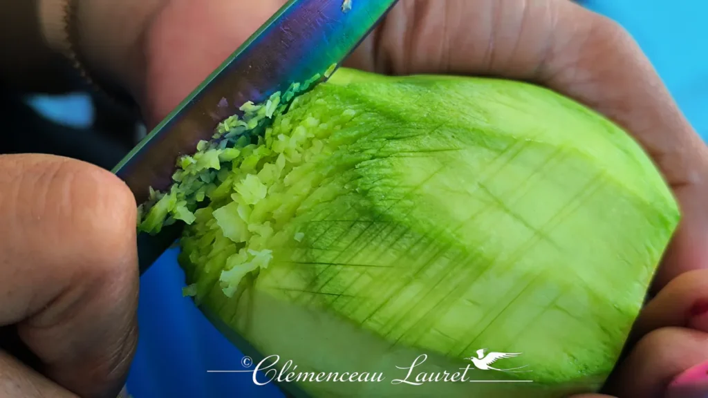 Vue rapprochée d'une mangue battue au couteau selon la méthode traditionnelle créole lors d'un atelier culinaire à Saint-Pierre.