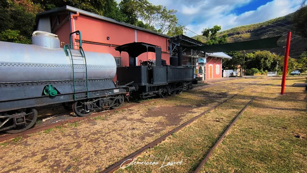 Convoi ferroviaire complet avec wagon-citerne gris et locomotive noire posés sur les rails de la Grande Chaloupe à La Possession.